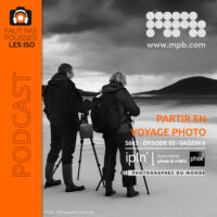 Photographes en voyage photo accompagné réglant leurs appareils face à un paysage de montagne enneigé
